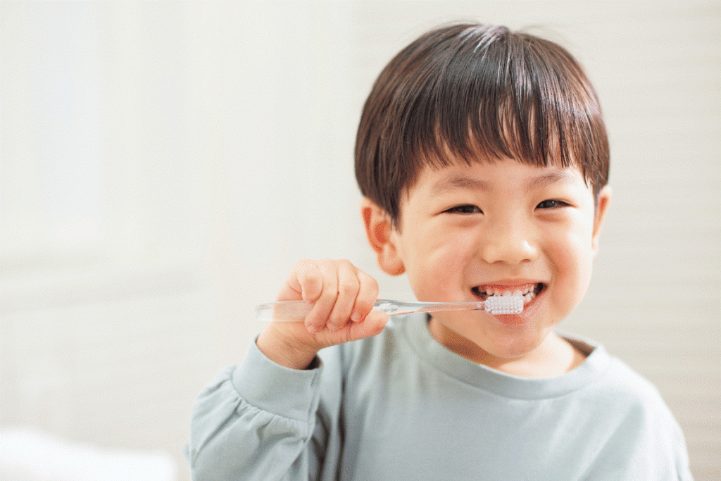 child brushing teeth with fluoride toothpaste under parent supervision